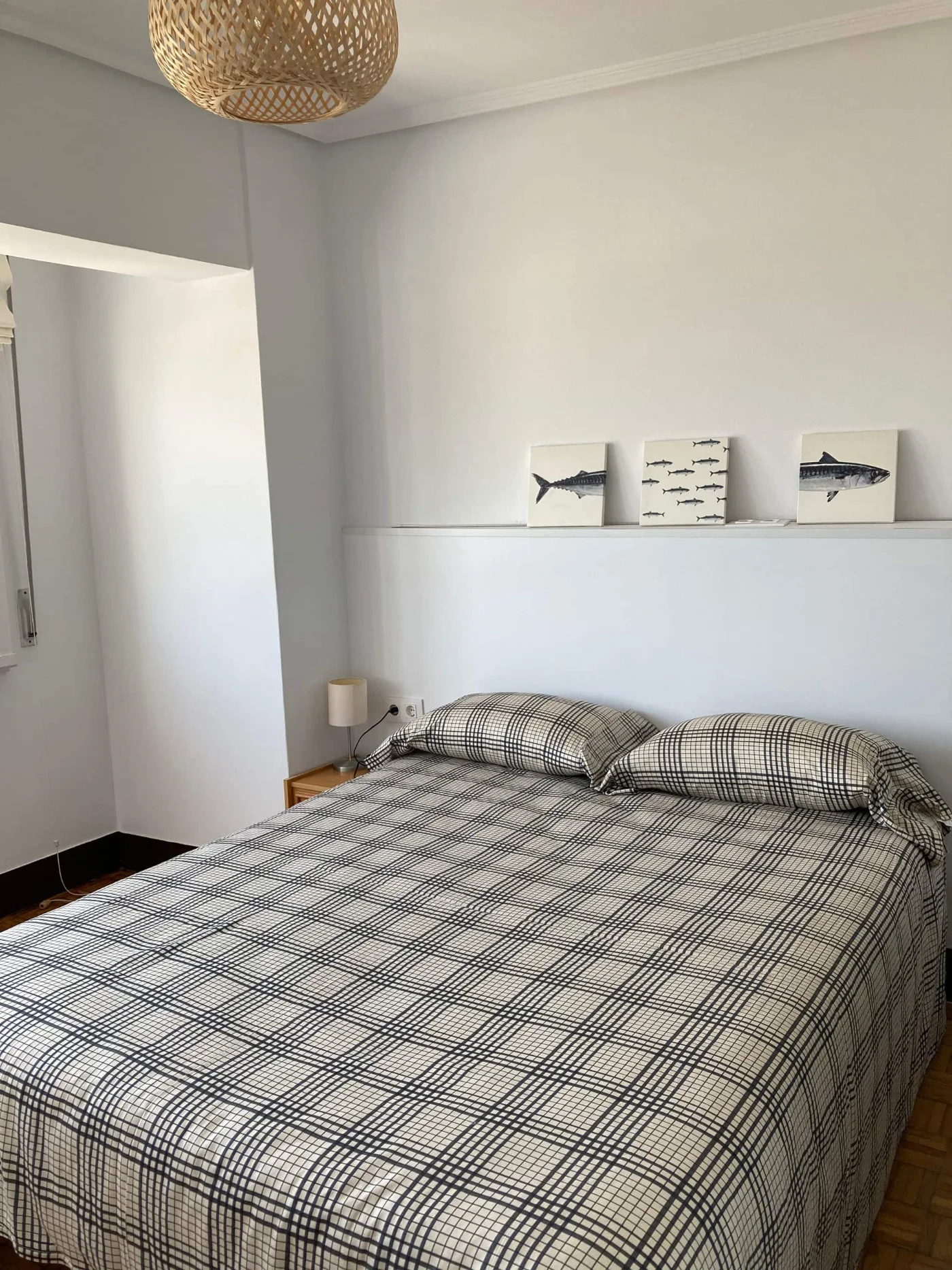 Dormitorio con cabecero y ropa de cama clara